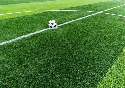 soccer field grass with ball at kick off point.